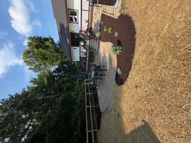Backyard patio with fresh mulch beds and new plantings