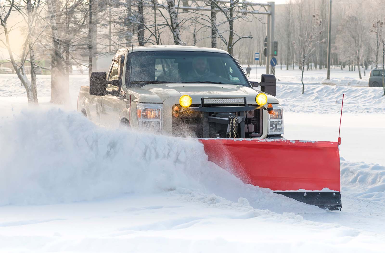 Snow plow clearing a winter road in snowy conditions